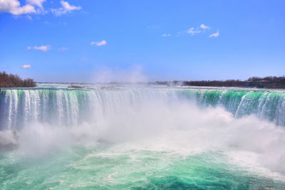 Scenic view of waterfall against sky