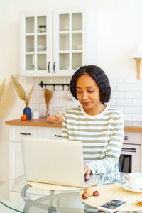 Young woman using laptop at table