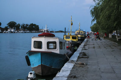 Boats moored on shore against clear sky