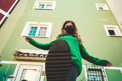 Low angle view of woman standing against building