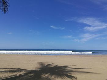 Scenic view of beach against blue sky