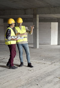 Architects discussing while standing at construction site