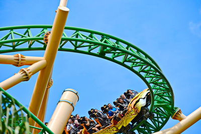 Low angle view of chain swing ride against blue sky