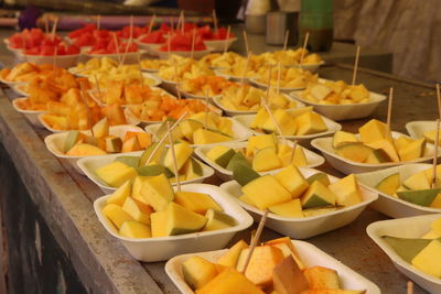 Fruits in bowls at market for sale