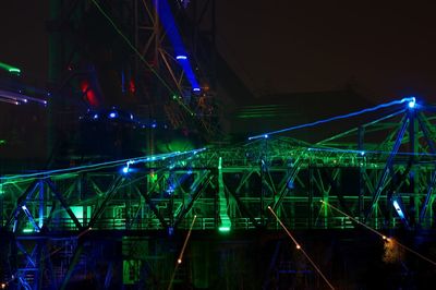 Illuminated bridge in city against sky at night