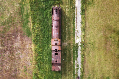 Rusty metallic structure on field by trees in forest