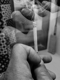 Close-up of hand holding cigarette