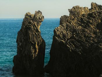 Rock formation on beach against sky