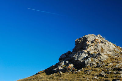 Low angle view of rock formation against clear blue sky