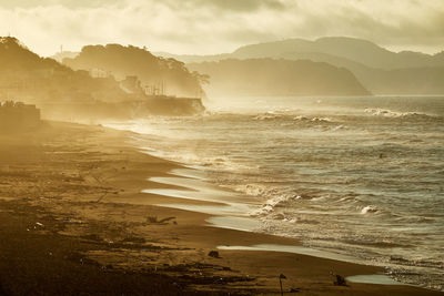 Scenic view of beach against sky during sunrise