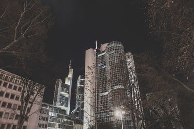 Low angle view of illuminated buildings against sky at night