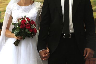 Midsection of women holding flower bouquet