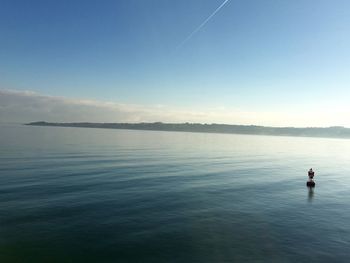 Man looking at lake against clear sky