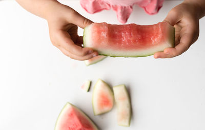 Close-up of hand holding apple against white background