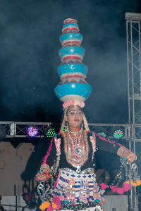 Midsection of woman with illuminated lighting equipment at night