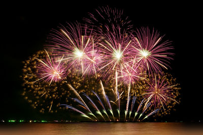 Firework celebration from the sea shore. colorful fireworks and the night sky background.