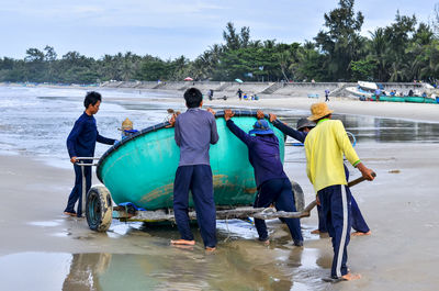 Men and people on water against sky