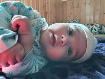 Portrait of cute baby lying on bed