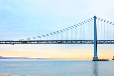 View of suspension bridge against cloudy sky