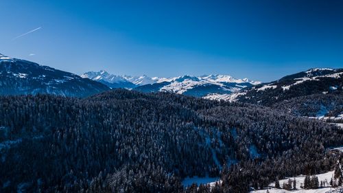 Scenic view of snowcapped mountains against blue sky