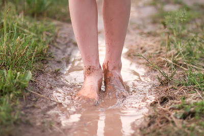 Low section of man standing on wet land