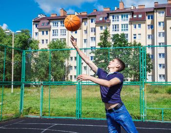 Man playing with basketball at court