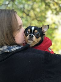 Woman with dog against trees