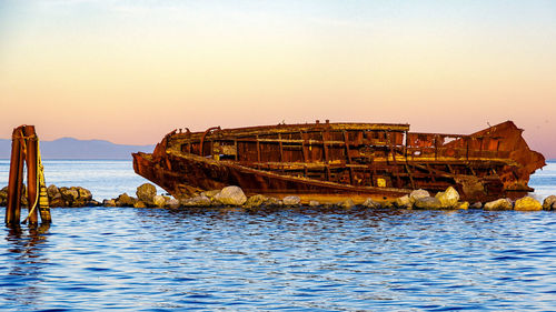 Abandoned ship in sea against sky