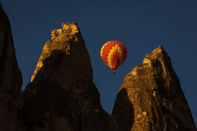 Low angle view of hot air balloon and mountains against sky