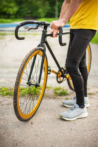 A young man stopped to rest with his bicycle in a public park. 