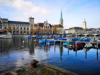 Boats moored in canal against buildings in city