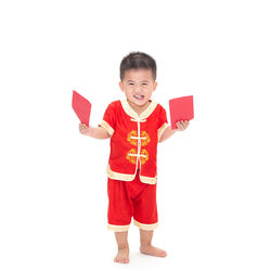 Portrait of smiling boy standing against white background