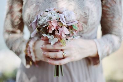 Midsection of woman holding flowering plant