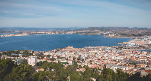 High angle view of townscape by sea against sky