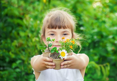 Portrait of boy blowing flowers