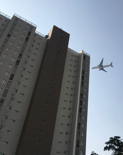 Low angle view of airplane flying against sky