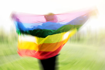 Blurred motion of woman holding rainbow flag