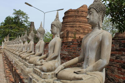 Statue of historic temple against building and trees