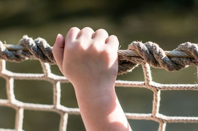 Close-up of hand holding rope