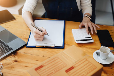 Midsection of woman working on table