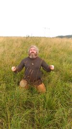 Man wearing mask on field against sky