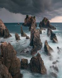 Scenic view of sea against cloudy sky during sunset