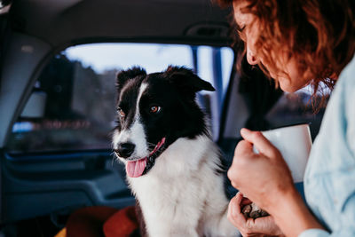 Close-up of woman with dog sitting in camper trailer