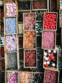 High angle view of colorful pearls in boxes at market for sale