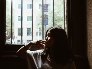 Portrait of woman drinking glass at home