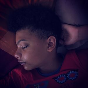 High angle view of boy sleeping on bed