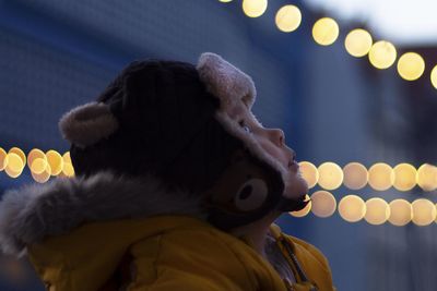 Portrait of woman looking at illuminated lights