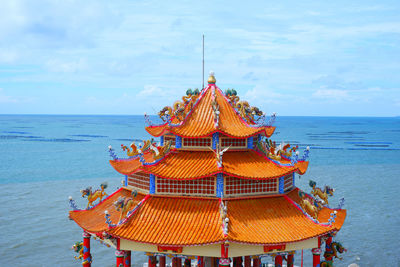 Temple by sea against sky