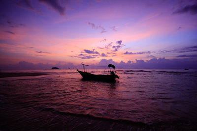 Silhouette boat in sea against sky during sunset