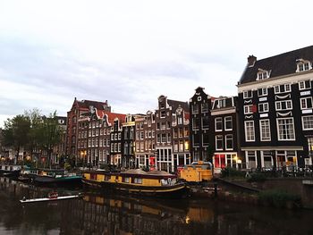 Boats moored on canal in city